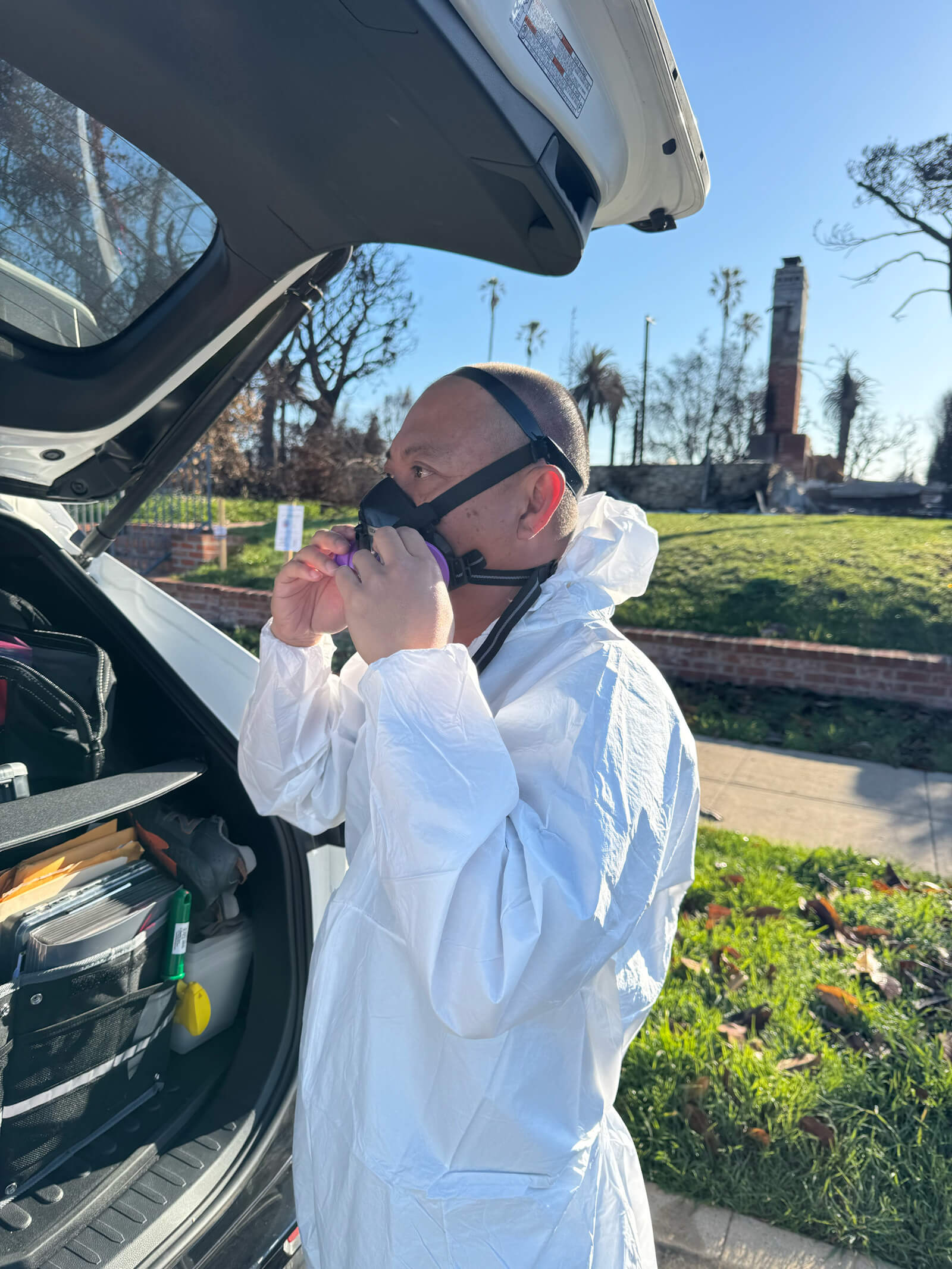 user-inserted Vert Environmental team member preparing for a wildfire contamination inspection in full protective gear.