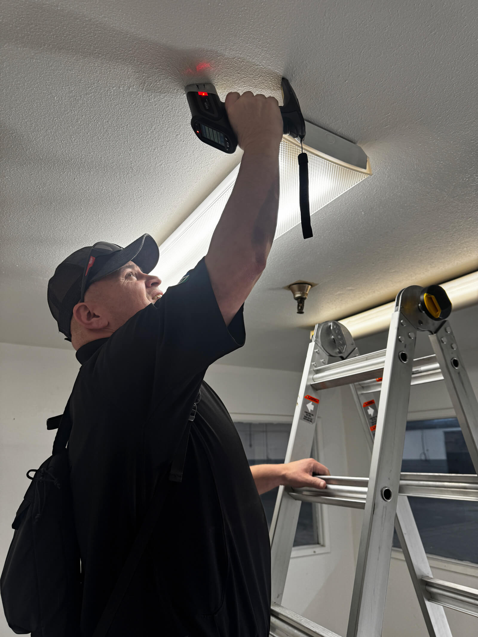 Vert Environmental professional performing an XRF lead-based paint analysis on a ceiling surface.