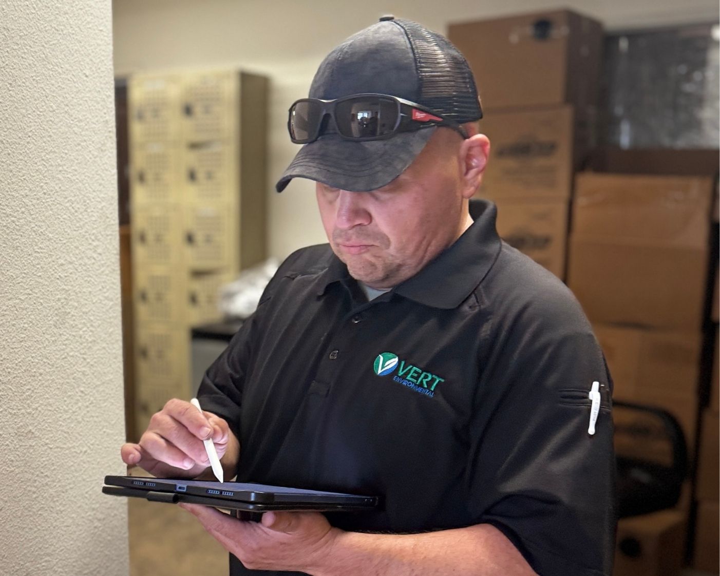 user-inserted VERT Environmental technician using a tablet during on-site environmental testing and inspection for commercial property safety and compliance.