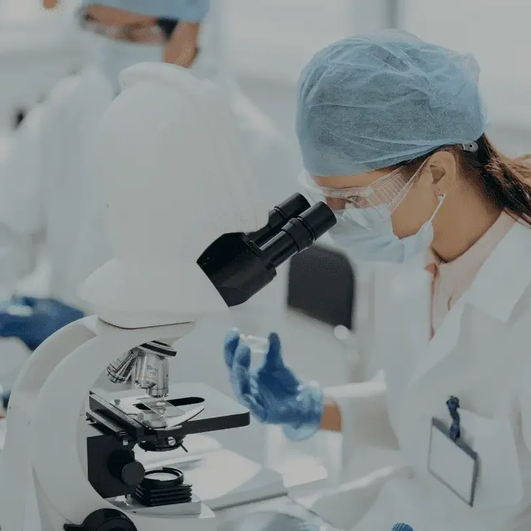 Professional VOC testing and air quality analysis: A scientist using a high-powered microscope to identify chemical contaminants and volatile organic compounds.