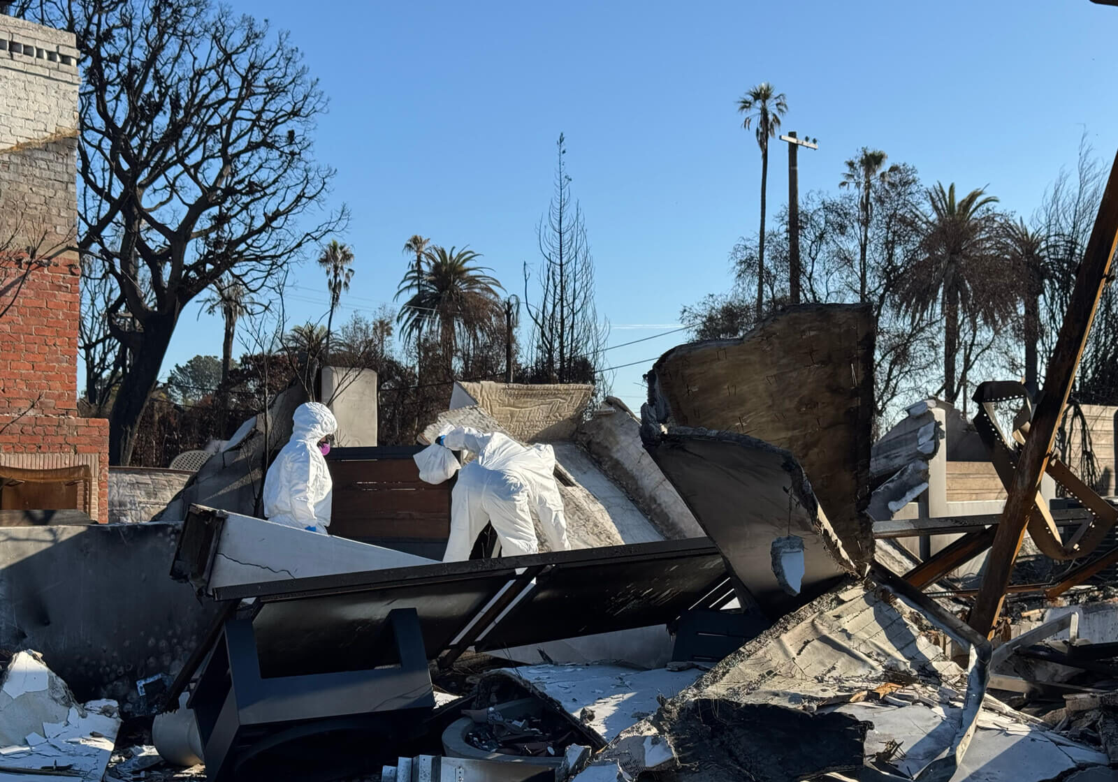 Vert Environmental specialists in protective gear conducting an environmental assessment at a fire-damaged property.